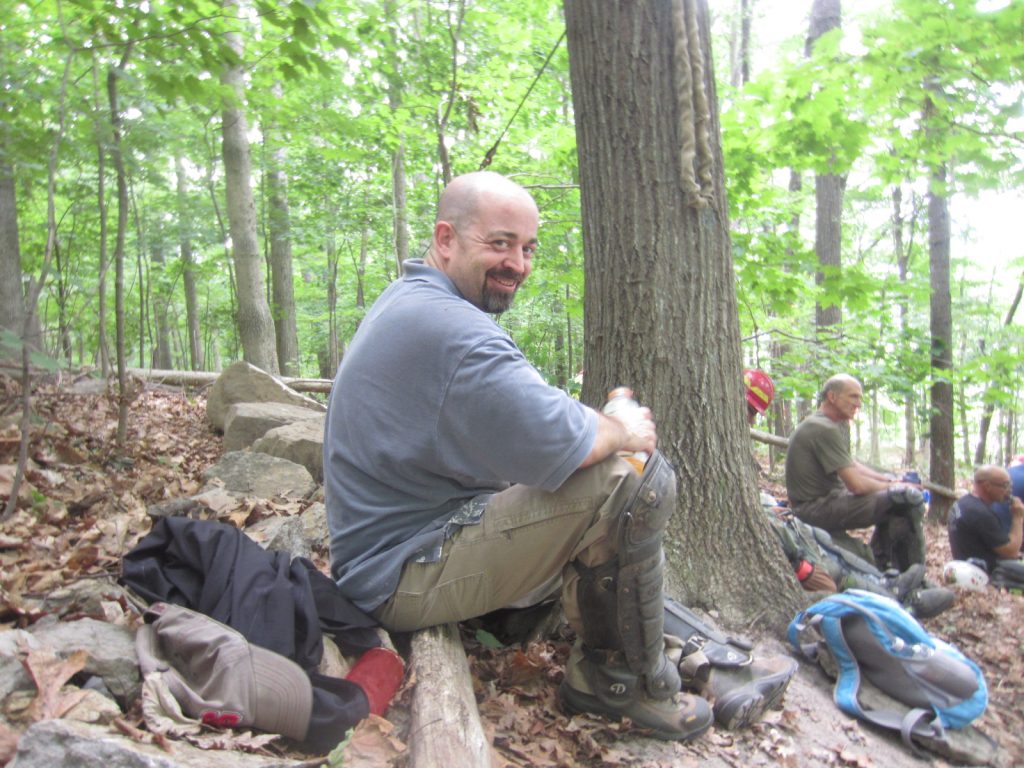 Dave taking a break during trail maintenance, looking over his should and smiling